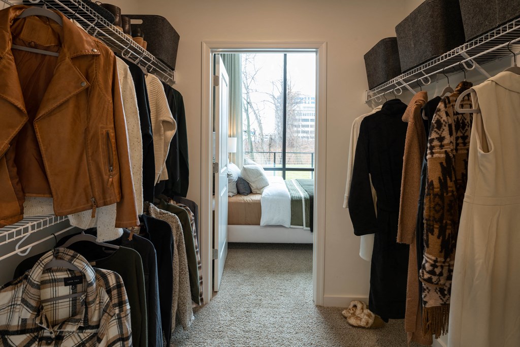 a walk in closet with a door leading to a bedroom  at Brentford at The Mile, Tysons