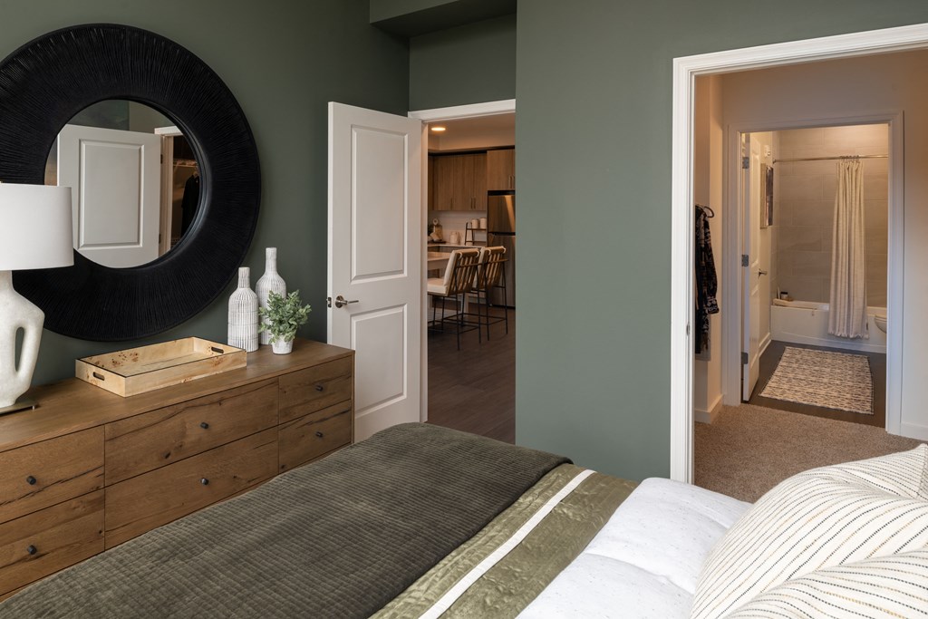 a bedroom with a bed and a mirror on the wall  at Brentford at The Mile, Virginia, 22102