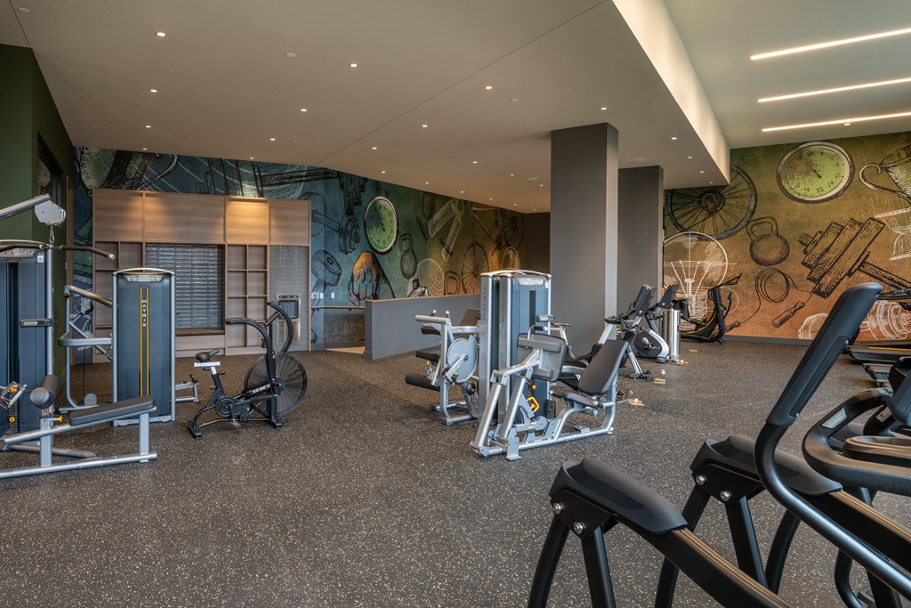 a gym with cardio equipment and a mural on the wall at Brentford at The Mile, Tysons, 22102