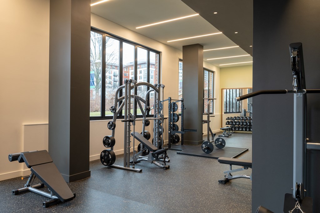 a gym with a lot of exercise equipment and a large window  at Brentford at The Mile, Tysons
