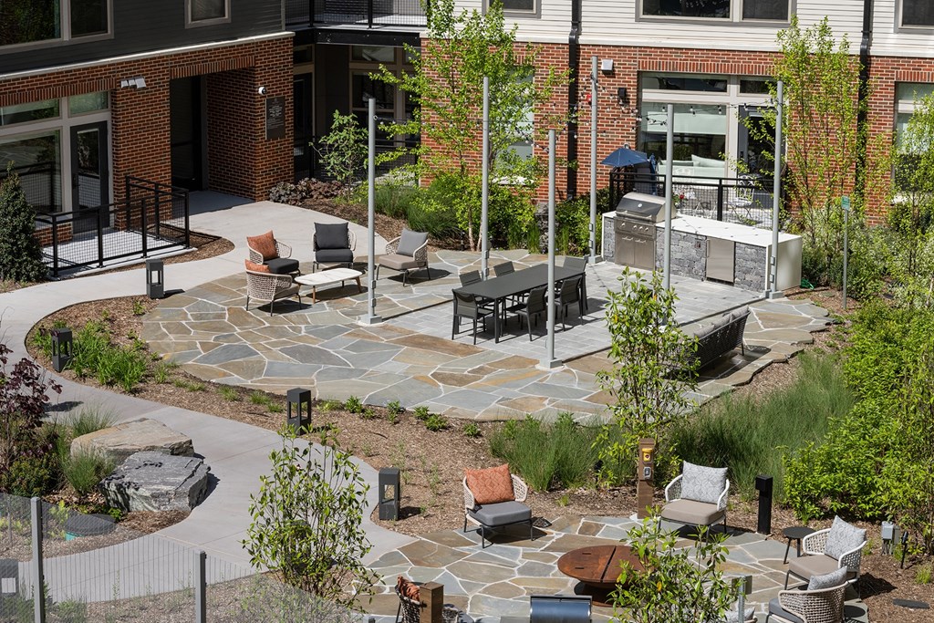 a patio with a fire pit and seating in front of a building at Brentford at The Mile, Virginia