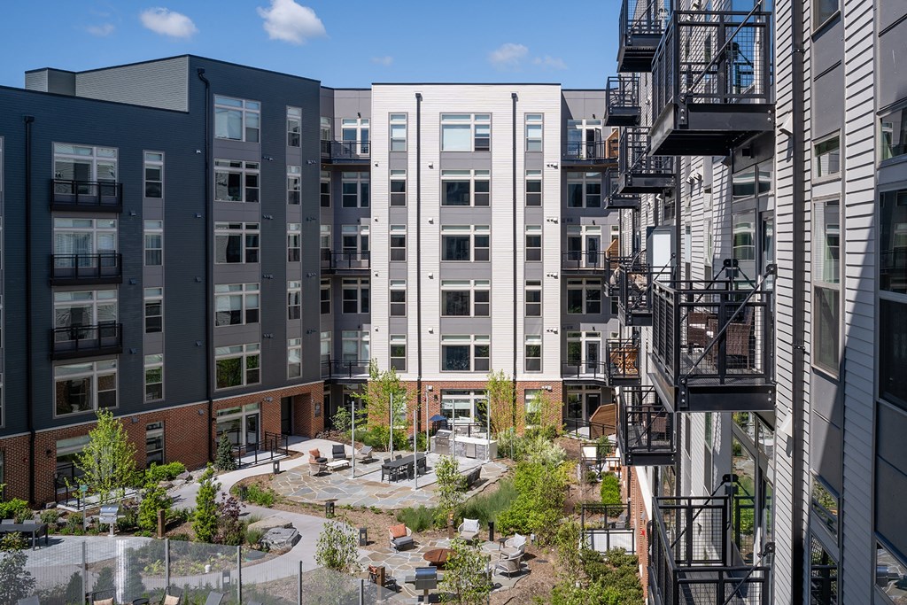 a courtyard with trees and a fountain in front of a building at Brentford at The Mile, Tysons, 22102
