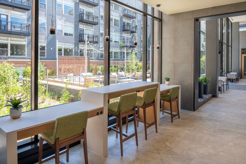 a room with a row of tables and chairs in front of a window with a view of at Brentford at The Mile, Virginia, 22102
