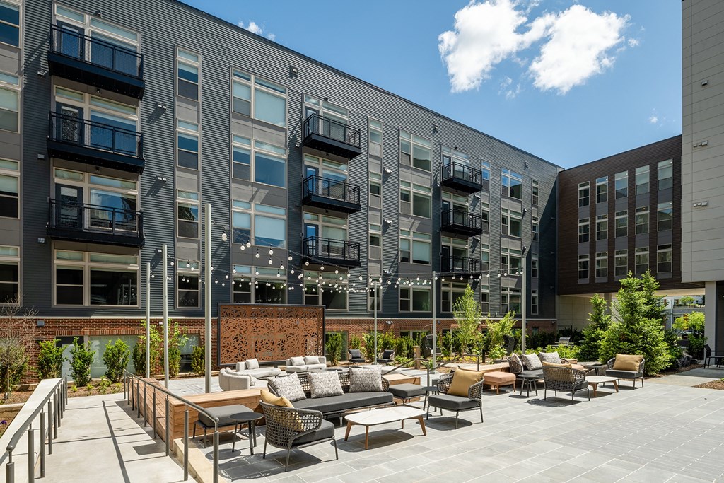 an outdoor patio with lounge seating and a firepit at the axis at walnut creek apartments at Brentford at The Mile, Tysons, VA