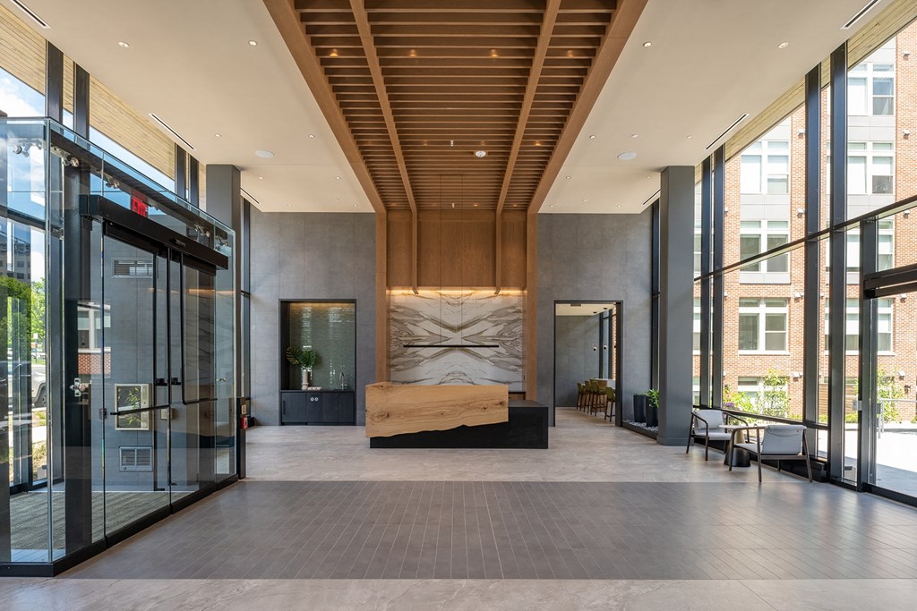 a large lobby with glass doors and a wooden ceiling at Brentford at The Mile, Tysons, Virginia