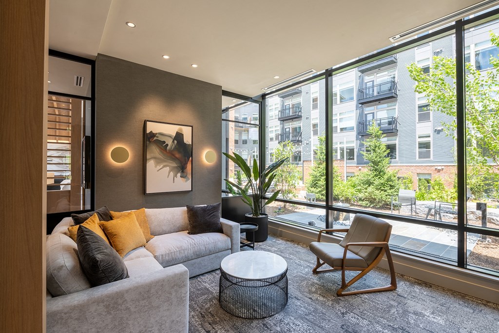 a living room with a large window and a couch and chair