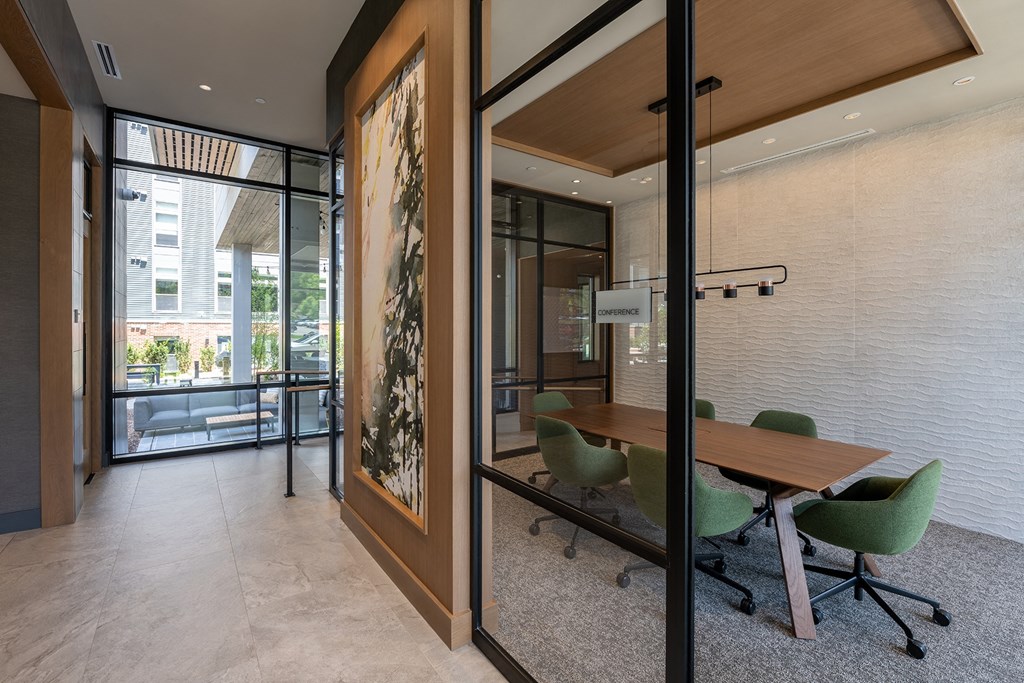 a meeting room with a wooden table and green chairs at Brentford at The Mile, Tysons, VA, 22102