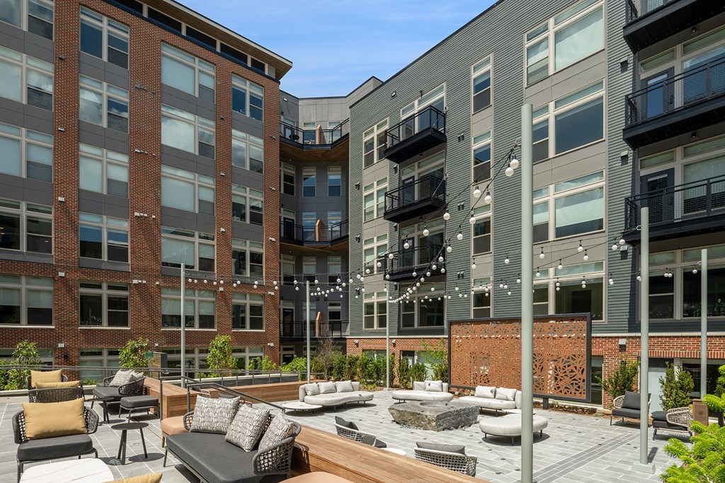 a courtyard with a firepit and lounge area at the central apartments near uptown and downtown at Brentford at The Mile, Tysons, 22102