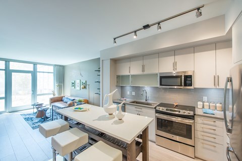 A modern kitchen with a large island and stainless steel appliances.