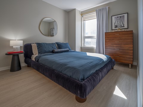 A bedroom with a large bed and a wooden dresser at Jayde Parkside in Washington, DC 20019