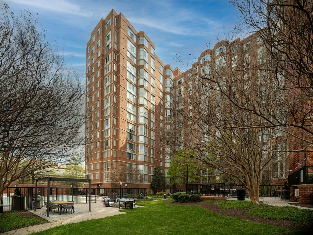 a park with benches in front of a tall building