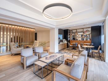 a lounge area with chairs and tables and a bar at Lincoln Old Town, Alexandria, 22314