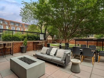 a patio with a couch and chairs and a fire pit at Lincoln Old Town, Alexandria, 22314