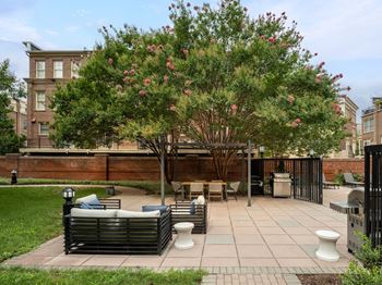 a patio with furniture and a tree in front of a building at Lincoln Old Town, Alexandria, 22314