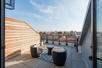a roof terrace with chairs and a view of the city