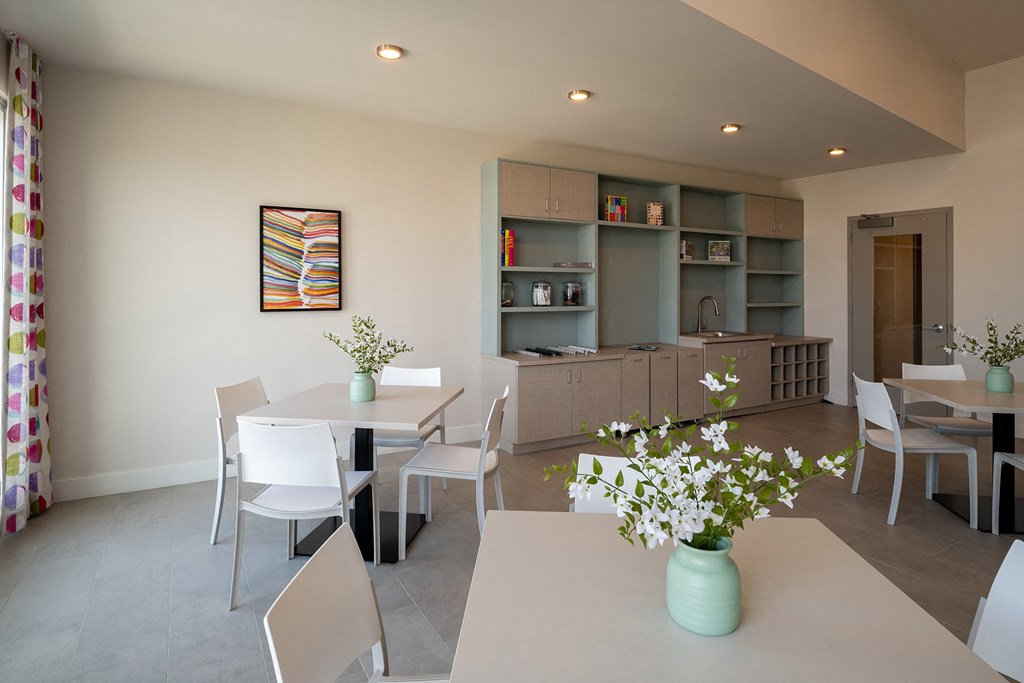 a room with a table and chairs and a kitchen in the background  at Woodmore Grand, Bowie, MD, 20721