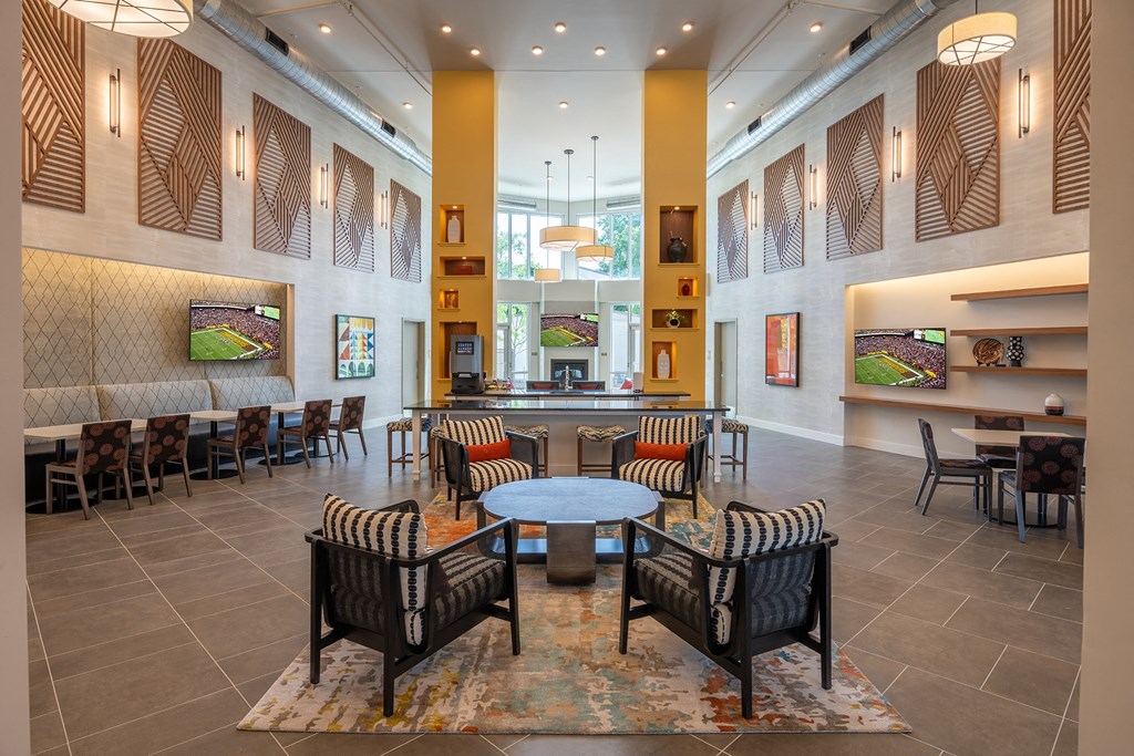 a seating area with tables and chairs in the atrium of a building  at Woodmore Grand, Bowie
