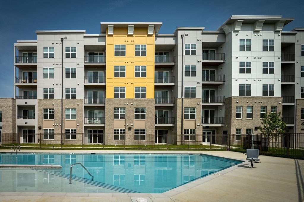 an image of an apartment building with a swimming pool  at Woodmore Grand, Bowie, MD, 20721