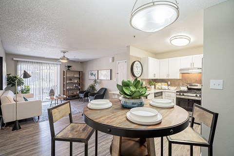 A dining room with a table set for two and a couch at Sterling Point Apartment Homes, Arizona