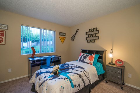 A bedroom with a bed, a desk, and a window at Sterling Point Apartment Homes, Arizona, 85042