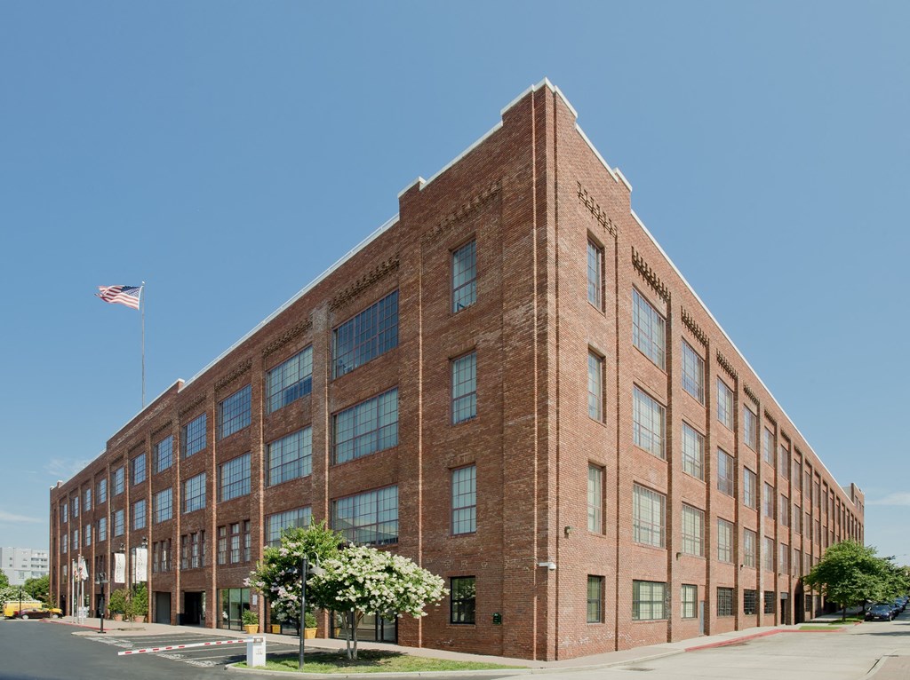 a large brick building with an flag in front of it at Tindeco Wharf, Baltimore