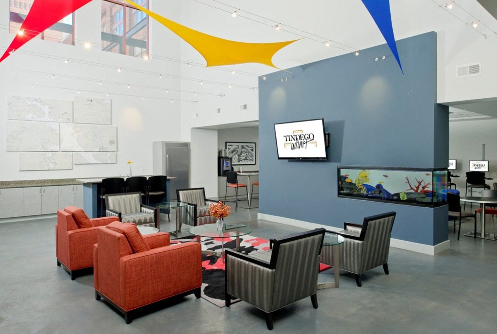 a conference room with orange chairs and a glass table and a wall with graphic design at Tindeco Wharf, Baltimore