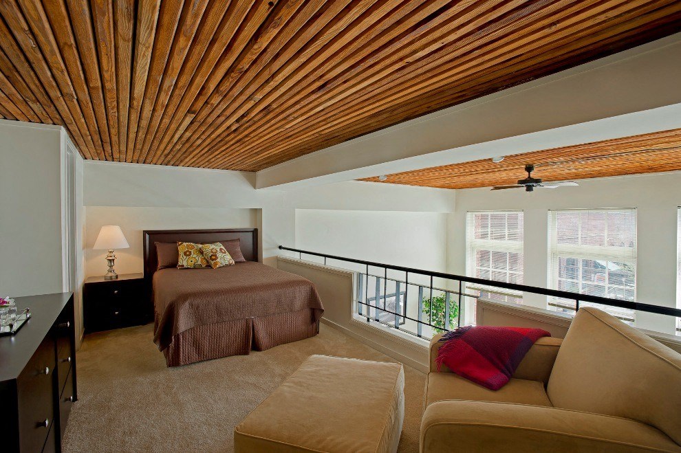 a bedroom with a bed and a couch and a balcony a bedroom with a bed and a couch and a balcony at Tindeco Wharf, Maryland