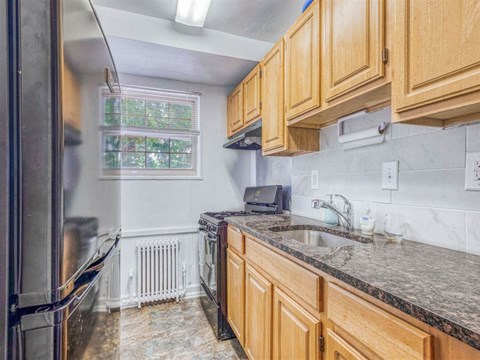 A kitchen with wooden cabinets and granite countertops.