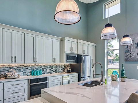 A kitchen with a white counter top and a refrigerator.