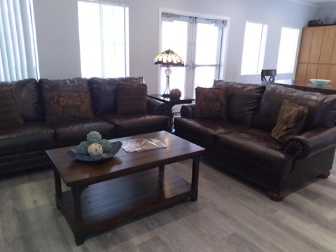 A living room with two brown couches and a coffee table.