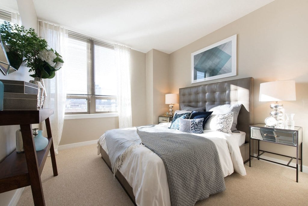 a bedroom with a large bed and two windows a bedroom with a large bed and two windows at The Acadia at Metropolitan Park, Arlington