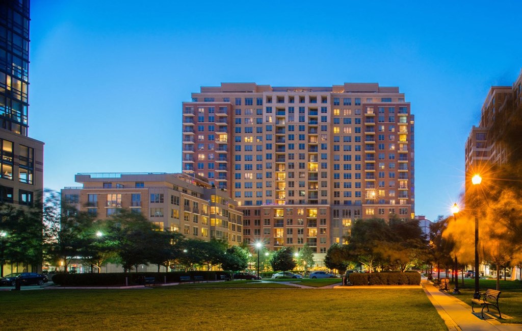a tall building with many windows and a grassy area in front of it at The Acadia at Metropolitan Park, Arlington, Virginia