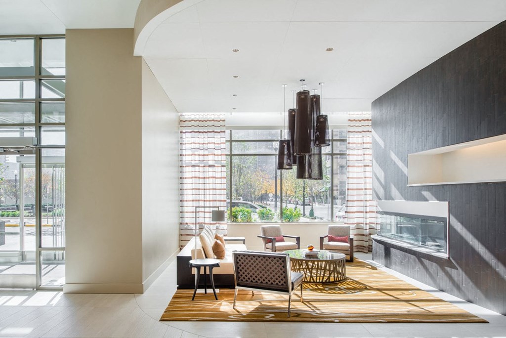 a living room with a fireplace and a large window at The Acadia at Metropolitan Park, Arlington, 22202