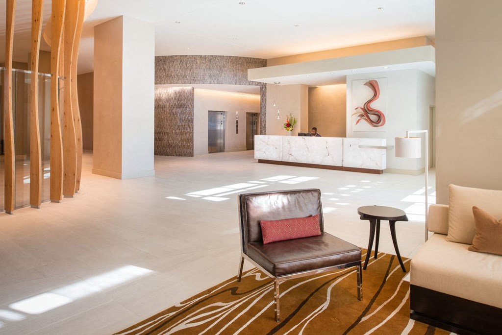 a hotel lobby with a brown chair and a brown and white rug at The Acadia at Metropolitan Park, Virginia, 22202