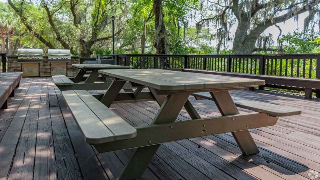a picnic table on a deck with trees