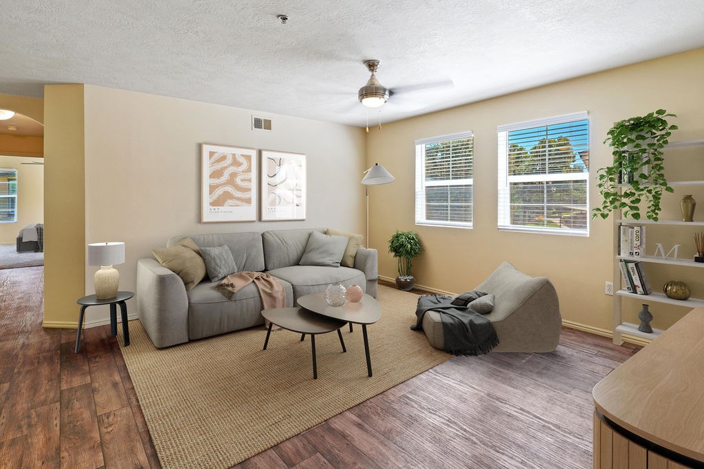 A living room with a grey couch and a rug. at Bluffs Apartments, Utah, 84065