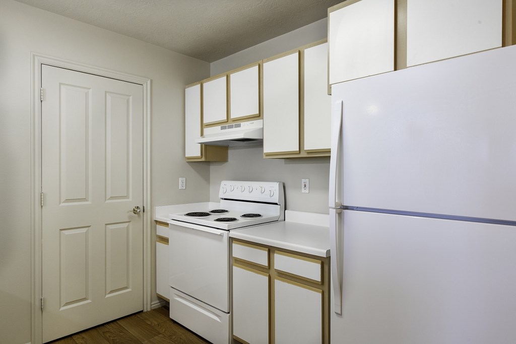 A white and gold kitchen with a white fridge. A white and gold kitchen with a white fridge. at Bluffs Apartments, Bluffdale, Utah