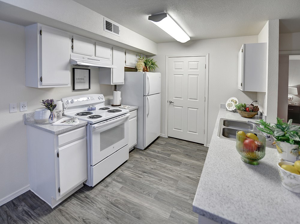 A small white kitchen with a refrigerator, stove, and sink.at Cottonwood Crossing, Casa Grande, Arizona  