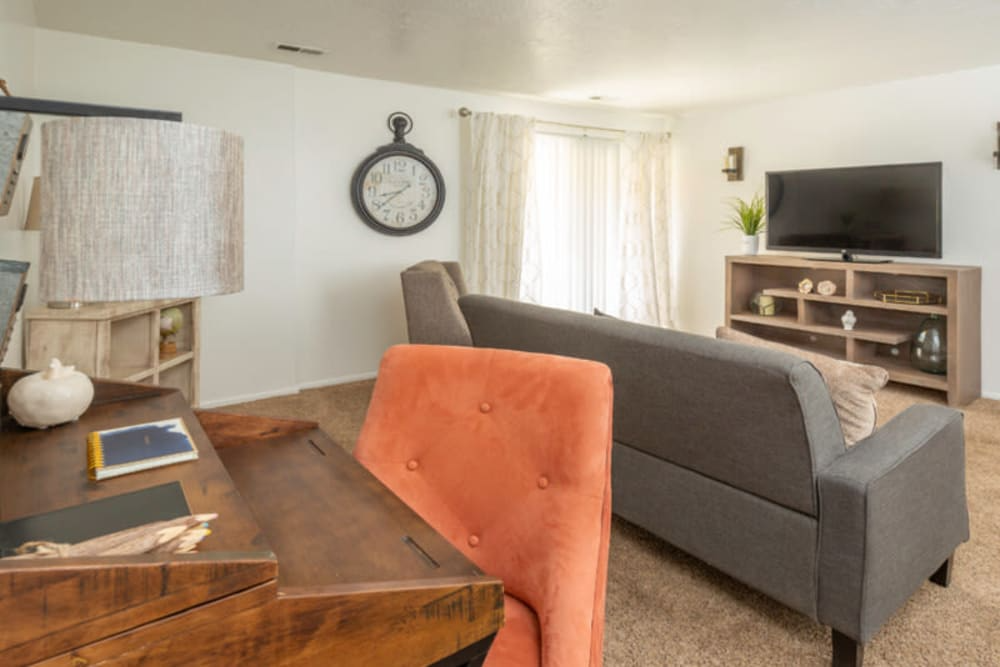 A living room with a grey couch, a wooden coffee table, and a television. A living room with a grey couch, a wooden coffee table, and a television.at Country Woods, Ogden, UT 84401
