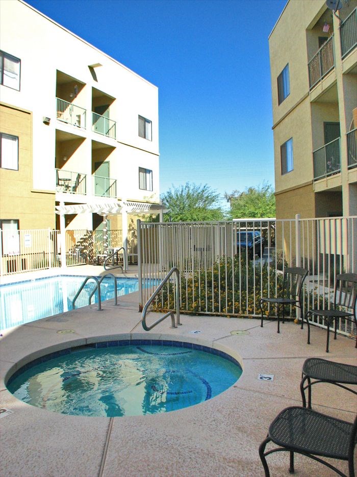 A small pool in a courtyard surrounded by chairs and buildings at Rancho Cielo Senior Apartments, Phoenix, AZ, 85009