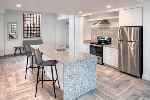 A kitchen with a granite countertop and a refrigerator.