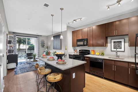 A modern kitchen with brown cabinets and a large island.
