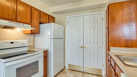 a kitchen with white appliances and wooden cabinets