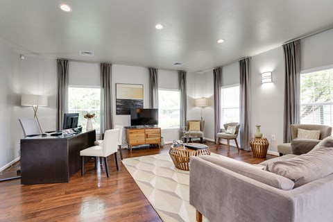A living room with a grey couch and a wooden floor.