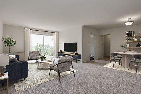 A living room with a blue sofa, grey carpet, and a flat screen TV.