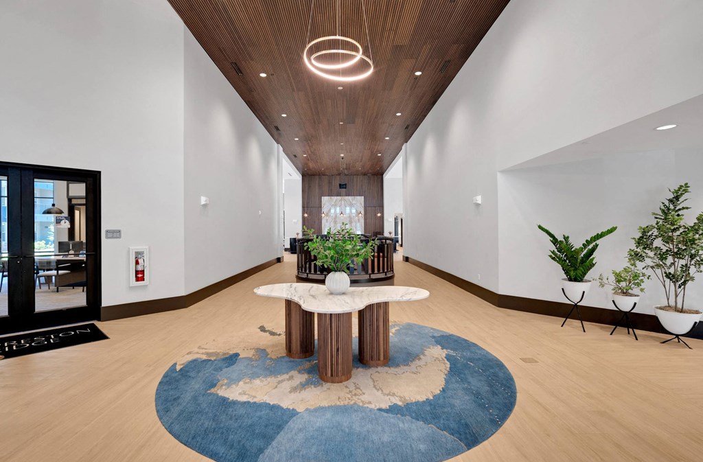 a lobby with a round table and a blue rug at Preston Ridge, Cary