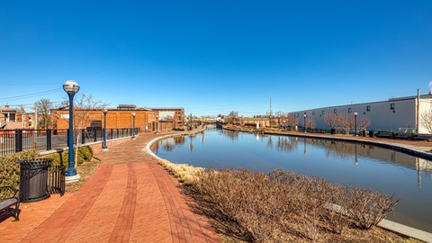 a canal with a brick walkway and buildings on the other side at North Market South Carroll, Frederick, MD 21701