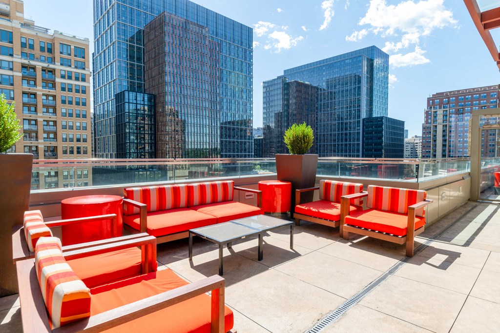 a rooftop patio with a view of the city and skyscrapers