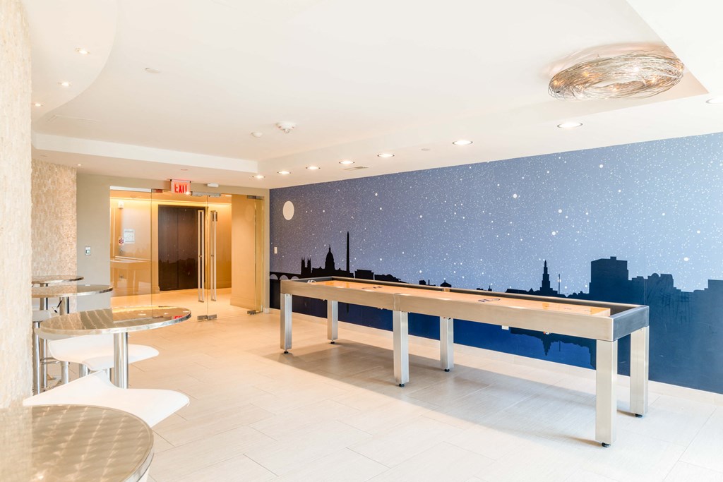 a game room with a pool table and a wall mural of the city skyline