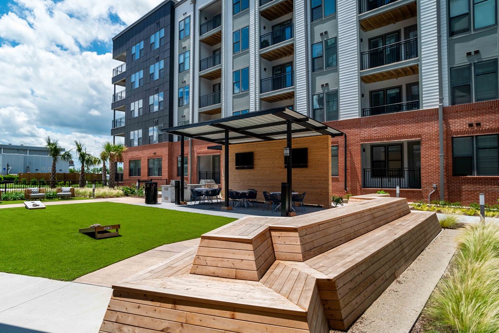 an outdoor area with benches and a picnic table in front at Metropolitan at the Riverwalk, Wilmington, North Carolina